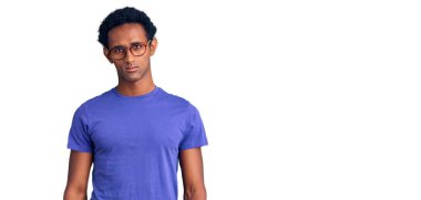 Sıradan kıyafetler giyen, gözlüklü, şüpheci ve gergin olan Afrikalı yakışıklı bir adam sorun yüzünden surat asıyor. negatif kişi. 