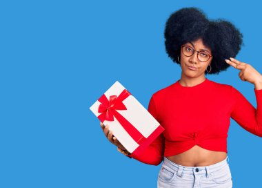 Genç Afrikalı Amerikalı kız elinde hediyeyle kendini vuruyor ve öldürüyor. Silah gibi elini ve parmaklarını işaret ediyor. İntihar hareketi.. 