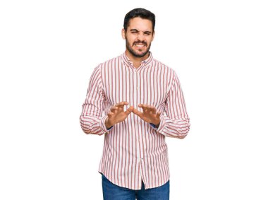 Young hispanic man wearing business shirt disgusted expression, displeased and fearful doing disgust face because aversion reaction. with hands raised 