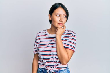 Kısa saçlı güzel bir kadın. Günlük kıyafetler giyiyor. Ciddi bir yüz ifadesi var. Elleri çenesinde soru sormayı düşünüyor. 