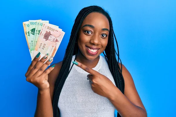 Joven Mujer Afroamericana Sosteniendo Surcoreano Ganó Billetes Sonriendo Feliz Señalando — Foto de Stock