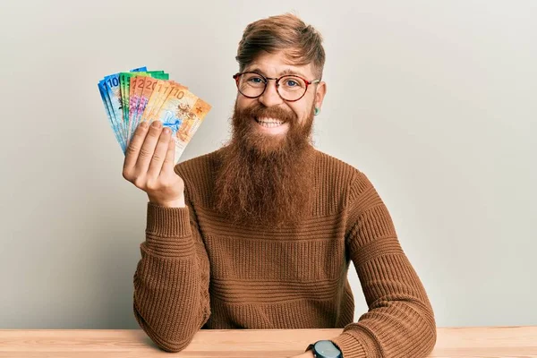 Young Irish Redhead Man Holding Swiss Franc Banknotes Sitting Table — Stock Photo, Image