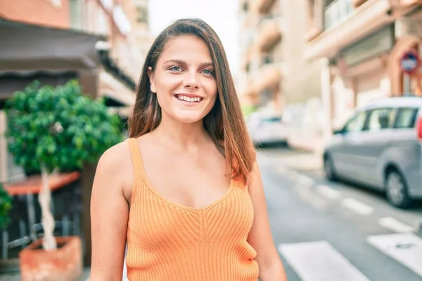 Genç ortadoğu kızı gülümseyerek şehirde mutlu mesut yürüyor..