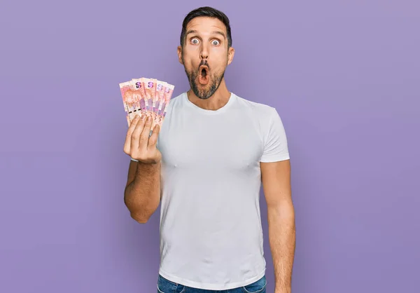 Hombre Guapo Con Barba Sosteniendo Billetes Sudafricanos Rand Asustado Sorprendido — Foto de Stock