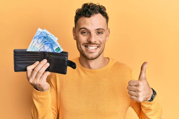 Joven Hombre Hispano Sosteniendo Billetera Con Billetes Rand Sudafricanos Sonriendo —  Fotos de Stock