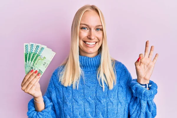 Young Blonde Girl Holding 10000 South Korean Won Banknotes Doing — Fotografia de Stock