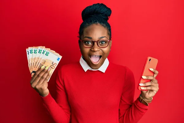 Молода Афроамериканська Жінка Користуючись Смартфоном Тримає Банкноти Євро Які Відзначають — стокове фото