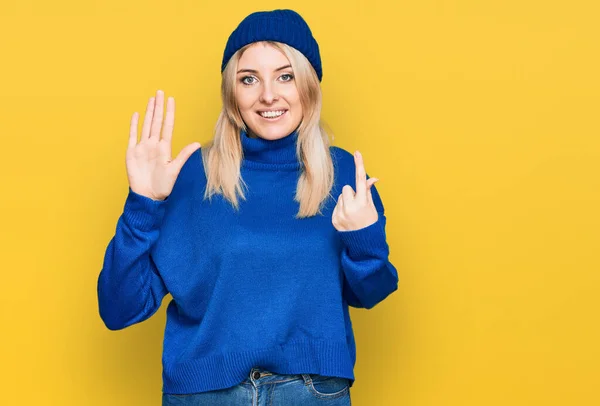 Junge Kaukasische Frau Trägt Wollenen Winterpullover Und Mütze Zeigt Mit — Stockfoto