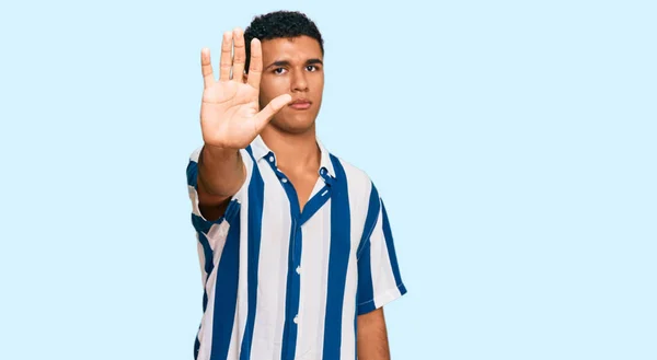 年轻的阿拉伯男子穿着休闲装 用手的手掌停止歌唱 用消极而严肃的手势警告人 — 图库照片