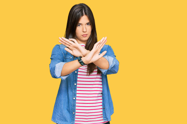 Young brunette woman wearing casual clothes rejection expression crossing arms and palms doing negative sign, angry face 