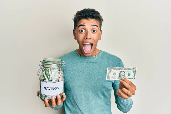 Joven Hombre Afroamericano Guapo Sosteniendo Tarro Con Ahorros Celebrando Loco — Foto de Stock