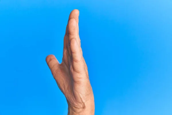 Mão Homem Hispânico Sênior Sobre Fundo Isolado Azul Mostrando Lado — Fotografia de Stock