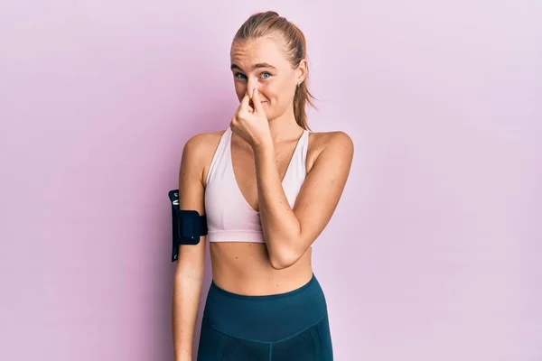 Mulher Loira Bonita Vestindo Roupas Esportivas Braço Banda Cheirando Algo — Fotografia de Stock