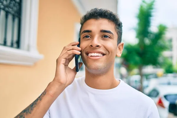 Junger Lateinischer Mann Lächelt Glücklich Und Spricht Auf Dem Smartphone — Stockfoto