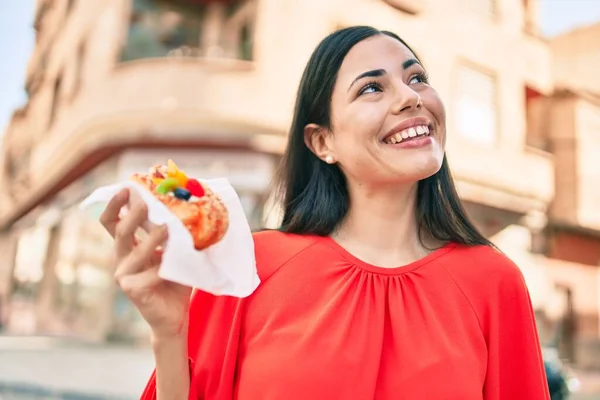 Joven Chica Latina Sonriendo Feliz Comiendo Dulce Caminando Ciudad —  Fotos de Stock