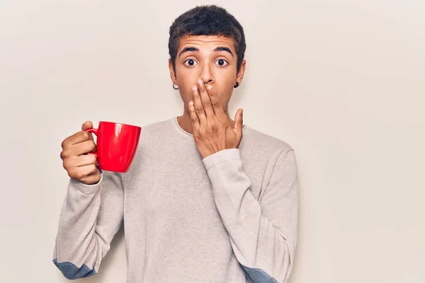 Young African Amercian Man Holding Coffee Covering Mouth Hand Shocked — Stock Photo, Image