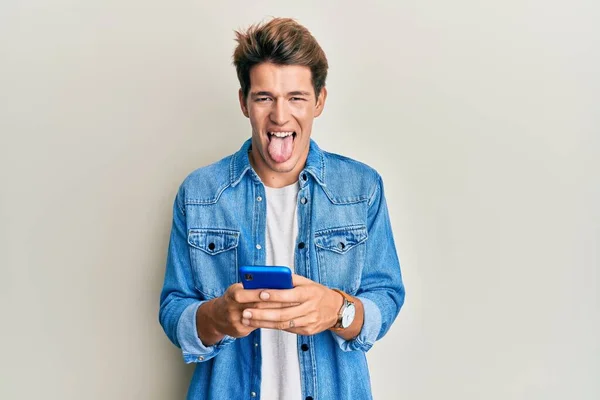 Bonito Homem Caucasiano Usando Smartphone Furando Língua Feliz Com Expressão — Fotografia de Stock