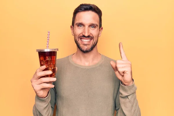 Jovem Homem Bonito Bebendo Bebida Refrescante Cola Sobre Fundo Amarelo — Fotografia de Stock