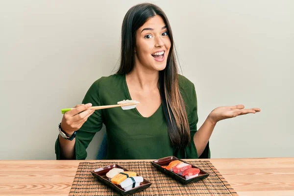 Joven Morena Comiendo Sushi Sentada Mesa Celebrando Logro Con Sonrisa — Foto de Stock