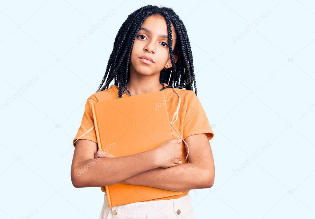 Cute african american girl holding notebook thinking attitude and sober expression looking self confident 