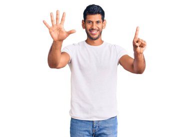 Gündelik kıyafetler giyen genç latin adam gülümseyerek kendinden emin ve mutlu gülümserken altı numarayı gösteriyor ve işaret ediyor.. 