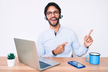 Ofiste çalışan yakışıklı İspanyol adam operatör kulaklığı takıyor gülümsüyor ve kameraya bakıyor.. 