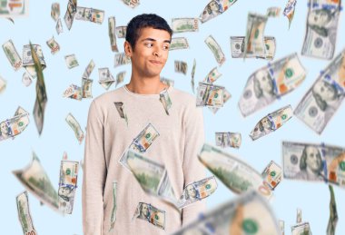 Genç Afrikalı Amerikalı, günlük kıyafetler giymiş, gülümseyen, yan tarafa bakan ve düşünen..