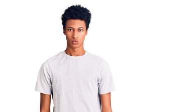 Gündelik kıyafetler giyen, kuşkucu ve gergin, sorun yüzünden surat asan genç Afro-Amerikan. negatif kişi. 