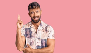 Yaz kıyafetleri giyen, gülümseyen, kameraya göz kırpan genç İspanyol adam zafer işareti yapıyor. İki numara.. 