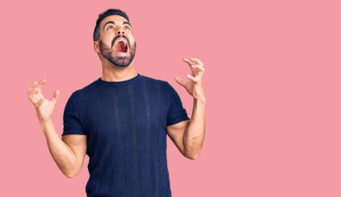 Gündelik kıyafetler giyen genç İspanyol adam deli gibi bağırıyor ve agresif bir ifade ve kollarla bağırıyor. hüsran kavramı. 