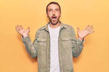 Sıradan kıyafetler giyen genç yakışıklı adam çılgın ve başarıyı kollarını kaldırıp heyecanla haykırarak kutluyor. Kazanan konsept 