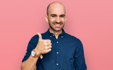 Gündelik kıyafetler giyen genç İspanyol adam elleriyle mutlu bir jest yapıyor. Kameraya bakıp başarıyı gösteren ifade. 