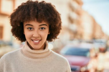 Genç İspanyol kız gülümseyerek şehirde mutlu mesut dikiliyor..