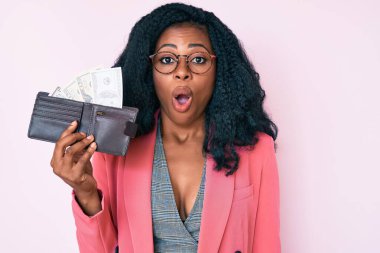 Dolarlarla dolu cüzdanı olan güzel Afrikalı bir kadın. Şaşırmak için ağzı açık kalmış, korkmuş ve şaşırmış. İnanmayan yüz. 