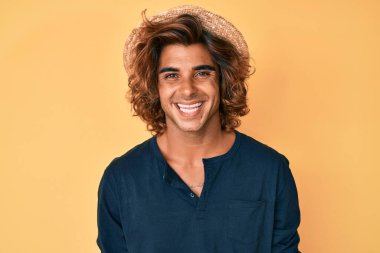 Yüzünde mutlu ve havalı bir gülümseme olan İspanyol şapkalı genç bir adam. şanslı kişi. 