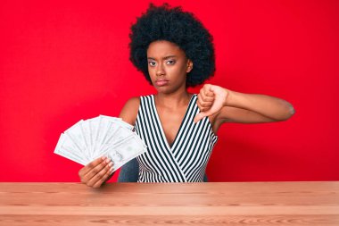 Kızgın yüzlü genç Afro-Amerikalı kadın, olumsuz işaret baş parmakları aşağıda, reddedilme konsepti 