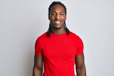 Saçları örgülü, mutlu ve havalı bir gülümsemesi olan Afro-Amerikan bir adam. şanslı kişi. 