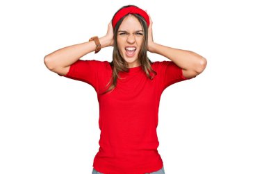 Genç esmer kadın gündelik kıyafetler giyiyor çılgın ve elleri başının üstünde korkmuş, korkmuş ve ağzı açık şoktan şaşırmış. 