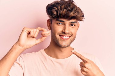 Makarna tutan genç İspanyol adam gülümsüyor. 