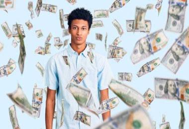 Gündelik kıyafetler giyen genç Afro-Amerikan adam yüzünde ciddi bir ifadeyle rahatlamış. Basit ve doğal bir şekilde kameraya bakıyorsun..