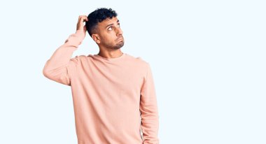 Gündelik kıyafetler giyen genç İspanyol adam soru sorup kafasını karıştırıyor. Şüpheyle kararsız, kafa kafaya düşünerek. Düşünceli kavram. 