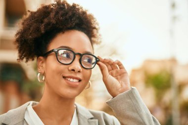 Genç Afrikalı Amerikalı iş kadını şehirde mutlu bir şekilde dikiliyor..