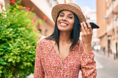 Genç Afrikalı Amerikalı turist kadın tatilde. Şehirdeki akıllı telefondan sesli mesaj dinliyor..