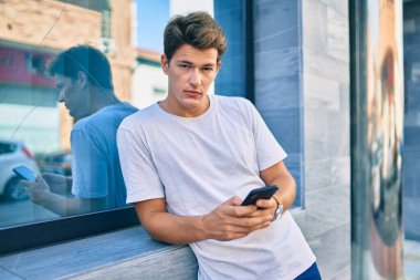 Beyaz adam şehirde akıllı telefon kullanarak mutlu bir şekilde gülümsüyor..