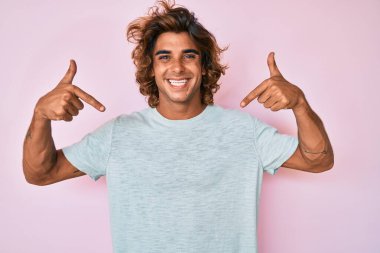 Günlük kıyafetler giyen, kendine güveni olan, kendini gururlu ve mutlu gösteren genç İspanyol bir adam.. 