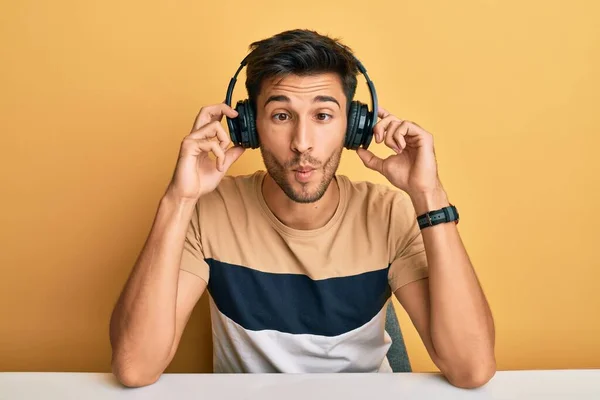 Jovem Bonitão Ouvindo Música Usando Fones Ouvido Fazendo Cara Peixe — Fotografia de Stock