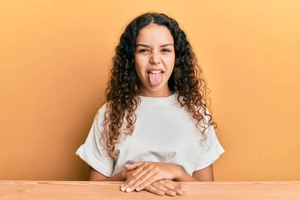 Adolescente Chica Hispana Con Ropa Casual Sentada Mesa Sacando Lengua —  Fotos de Stock