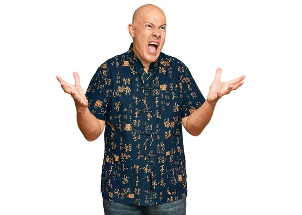 Orta yaşlı, kel, sıradan kıyafetler giyen çılgın ve deli gibi bağıran saldırgan bir ifade ve kollarla bağıran bir adam. hüsran kavramı. 