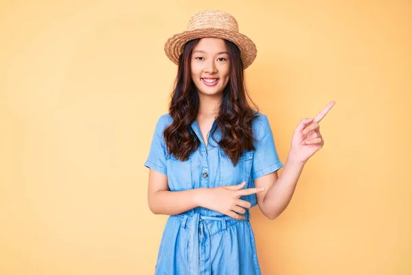 Νεαρή Όμορφη Κινέζα Που Φοράει Καλοκαιρινό Καπέλο Χαμογελώντας Και Κοιτάζοντας — Φωτογραφία Αρχείου