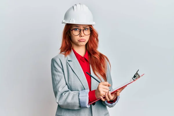 Jonge Roodharige Vrouw Met Een Architectenhelm Depressief Bezorgd Verdriet Huilend — Stockfoto